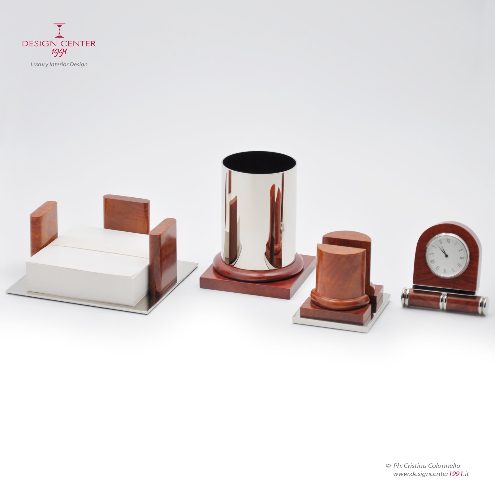 il set comprende portapenne, orologio, porta biglietti da visita e porta foglietti appunti in radica pregiata, colore rosso arancio. design moderno e richiami architettonici classici.